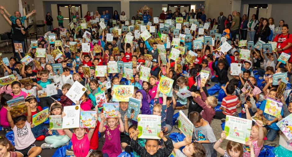 Large group of children holding books